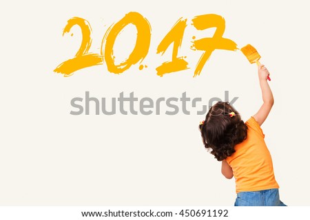 Cute little girl drawing new year 2017 with painting brush on wall background