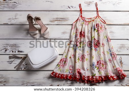 Floral sarafan and footwear. Sarafan and shoes on showcase. Woman's simple outfit for summer. Garment of light fabric.