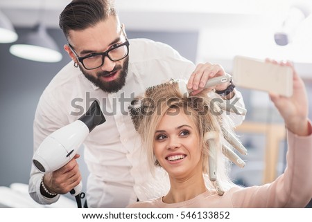 Laughing girl is taking picture with a stylist