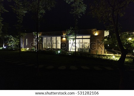 Flamingo Dai Lai, Vinh Phuc province, Vietnam - October 11, 2016 : beautiful living room of a villa overlooking the garden at night with the rocks on the grass at Flamingo Dai Lai resort