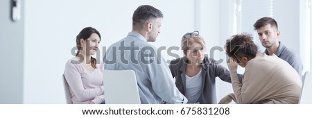 Rehab group sitting in a circle with therapist comforting woman