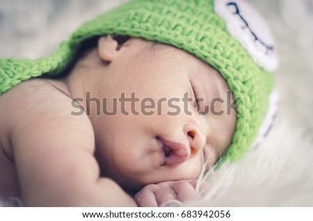Close-up shot,cute adorable newborn baby sleeping on furry mat.motherhood and parenting concept.