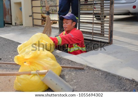 Muadzam Shah, Malaysia - March 22nd, 2018: Municipal workers "Alam Flora" uses sweepers and shovels to clean the garbage in the drain and put into the garbage bag.