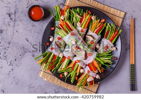 Spring rolls with vegetables and shiitake mushrooms on a plate, top view.