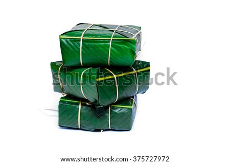 Uncooked Vietnamese Chung Cake isolated on white. Its a square glutinous sticky rice cake, stuffed with pork meat, green beans and wrapped in bamboo leaf. Traditional Vietnamese New Year. Copy space.