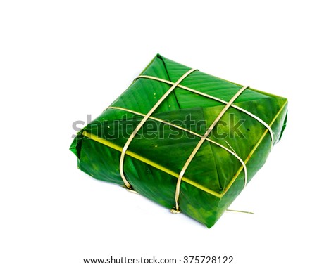 Uncooked Vietnamese Chung Cake isolated on white. Its a square glutinous sticky rice cake, stuffed with pork meat, green beans and wrapped in bamboo leaf. Traditional Vietnamese New Year. Copy space.