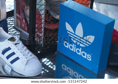 Berlin, Germany - April 26, 2016: Adidas logo and shoes in shop window. Adidas AG is a German multinational corporation that designs and manufactures sports shoes and clothing headquartered in Bavaria