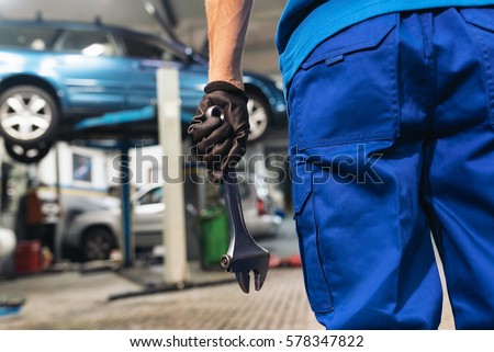 Professional Mechanic Repairing Car Engine in Garage.