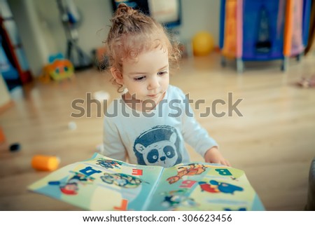 girl trying to read a children's book