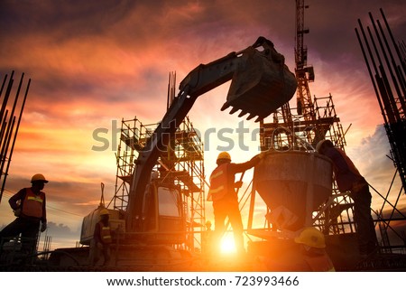 Silhouette Teams of Business Engineers looking for blueprints in construction sites through blurry construction sites at sunset.