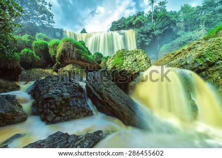 Elephant Falls on a summer afternoon with old plaster stone structure, water, splashing, yellow water contains silt due from basaltic soils here are considered beautiful natural waterfall of Lam dong