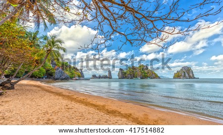 Landscapes coast with big rocks beautiful beach front cloudy blue sky, foreground tree overlooking beautiful bay, which attracts many tourists and recognized landscapes Vietnam national level