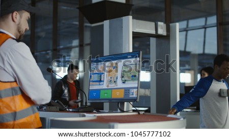 Man in uniform watching monitor with x-ray of baggage checking passengers in airport.