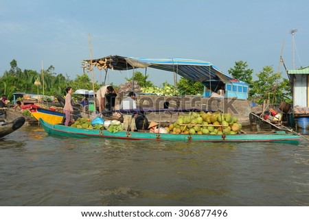 TIEN GIANG PROVINCE, VIETNAM - FEB 11, 2015: Flower vendors on their boats at Cai Be Floating Market. Cai Be Market is one of most famous floating market in Vietnam.