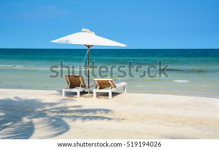 Idyllic tropical beach with relaxing chais and umbrella in sunny day at summer