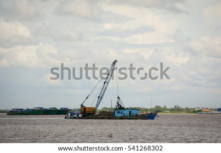 Landscape of Mekong River in Southern Vietnam. A cargo boat carrying sand on the Bassac river in An Giang, Vietnam.