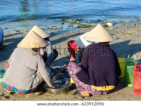 Phan Thiet, Vietnam - Mar 19, 2016. Group of women with conical hat sitting at pier in Mui Ne town, Phan Thiet, Vietnam. Mui Ne is a coastal fishing town in the Southern Vietnam.