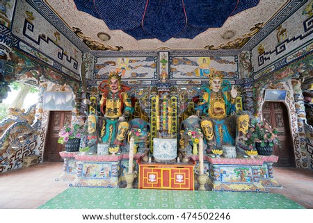 NHA TRANG, VIETNAM - JUNE 23, 2016: Statues of gods in the Buddhist temple. Walls and floor are made of a multi-colored mosaic