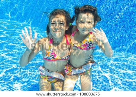 happy smiling underwater children in swimming pool beautiful girls swim and having fun kids - Kids Swimming Underwater happy smiling underwater children in swimming pool beautiful girls swim and having fun kids - Kids Swimming Underwater