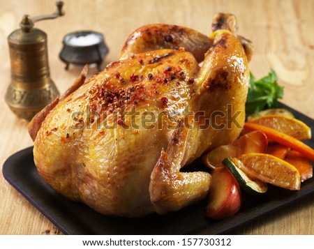 Grilled chicken and various vegetables on wooden plate - stock photo