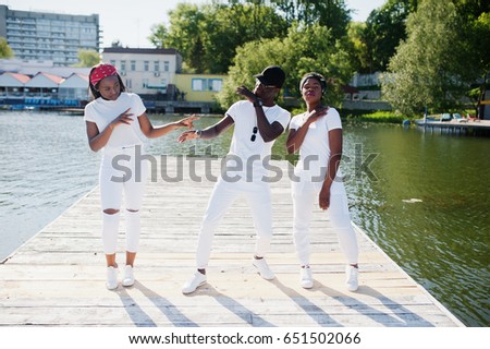 stock-photo-three-stylish-african-american-friends-wear-on-white-clothes-at-pier-on-beach-showing-dab-street-651502066.jpg