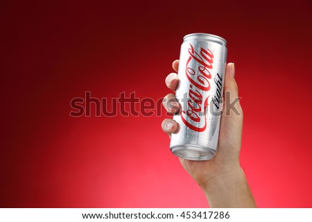Kuala Lumpur,Malaysia 11th July 2016, Hand hold a can Coca-Cola light on red background. Coca Cola drinks are produced and manufactured by The Coca-Cola Company.