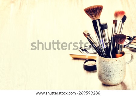 Various makeup brushes on light background with copyspace