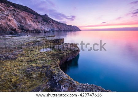 Wonderful dawn over large rock in calm waves at Nui Chua national park, Ninh Thuan Province, Viet Nam, one of amazing landscape in Vietnam, masterpiece place for travel.