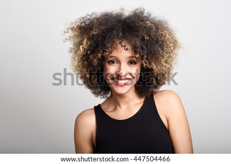 Young black woman with afro hairstyle smiling. Girl wearing black 