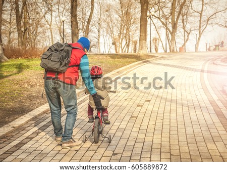 Father and son learning to ride a bicycle. happy toddler boy riding bike. Kids enjoying a bicycle ride. Active toddler. Sport concept.