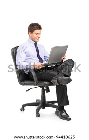 Young smiling businessman sitting in office chair and working on laptop computer isolated on white background