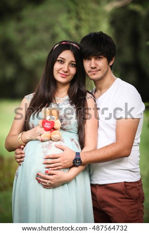 https://thumb9.shutterstock.com/display_pic_with_logo/3404252/487564732/stock-photo-pregnant-woman-smiling-to-camera-hugged-by-husband-lovely-cute-family-487564732.jpg