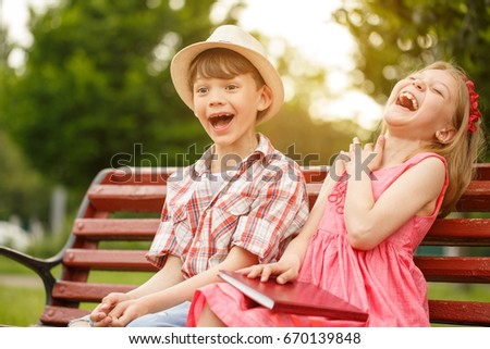 shot of two happy little kids boy and girl laughing joyfully sitting together at the park - Images Of Little Kids shot of two happy little kids boy and girl laughing joyfully sitting together at the park - Images Of Little Kids
