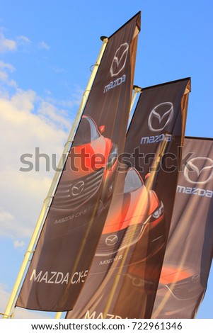 Samara, Russia - August 20, 2016. festive flags with the emblem of car MAZDA is developing the wind against the blue sky, about autofocus car sales