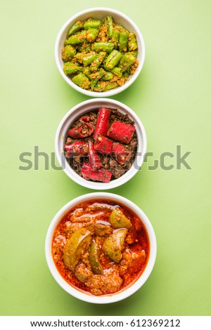 group photo of indian traditional  Mango pickle / aam ka achar, hari mirch achar / green chilli pickle, red chilli pickle / lal mirch ka achar, served in 3 white bowls, selective focus