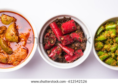 group photo of indian traditional  Mango pickle / aam ka achar, hari mirch achar / green chilli pickle, red chilli pickle / lal mirch ka achar, served in 3 white bowls, selective focus