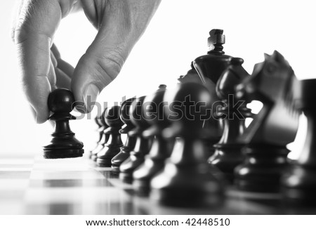 chess player hand moves pawn selective focus black and white