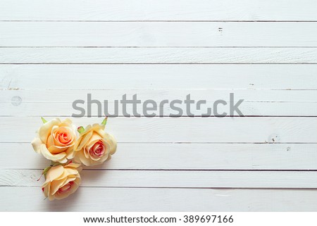 Background with a three peach roses on painted wooden planks. Place for text.