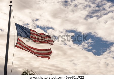 stock-photo-american-flag-torn-down-the-middle-twisting-in-the-wind-on-a-cloudy-sky-566811922.jpg