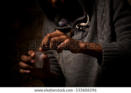 Drug addict man using narcotics or drugs on street. Man holding white powder. Disease concept. Drugs concept.