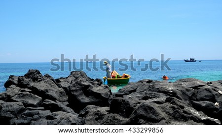 LYSON ISLAND, QUANG NGAI PROVINCE, VIETNAM - JUNE 2016: Unidentified fisherman is dragging the punt on the blue sea of Ly Son island. Ly Son is an ancient volcanic island.
