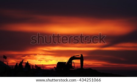 LY SON ISLAND, VIETNAM - JUNE 2016 : Beautiful sunset over boats on the sea of Ly Son island, Quang Ngai province, Vietnam. Flag and crane waving in the red sky. Revolution abstract. Sihouette.