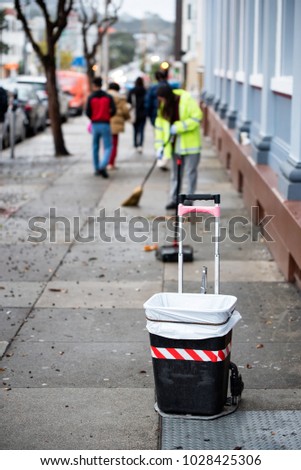 Road sweeper worker cleaning footpath with broom tool in USA