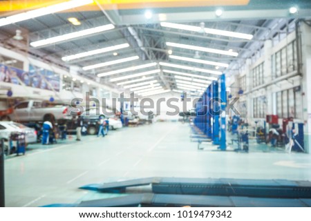 Abstract blur car technicians repairing cars in workshop service station background.