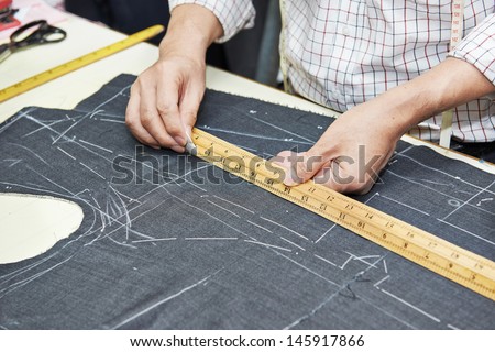Tailor hands working with measure bar
