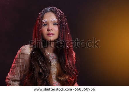 https://thumb9.shutterstock.com/display_pic_with_logo/3949610/668360956/stock-photo-beautiful-asian-girl-in-glitter-snowflake-and-smoke-in-dark-background-half-body-portrait-lady-668360956.jpg