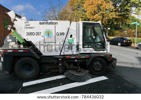 New York City, USA - November 16, 2017: A street sweeper vehicle cleans a road in the Kew Gardens borough of Queens. The NYC Department of Sanitation is responsible for cleaning the city's streets.