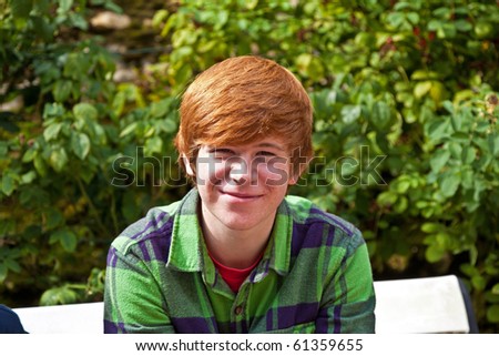 boy sitting on a bench in a park