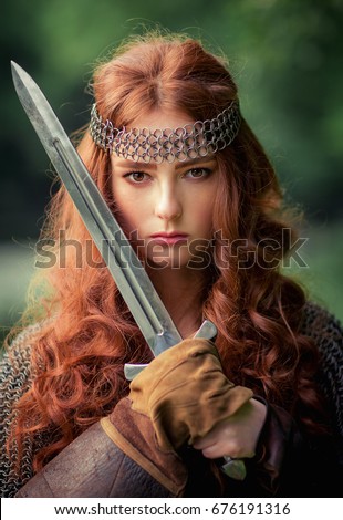 stock photo beautiful red haired girl in metal medieval armor dress with sword standing in warlike pose and 676191316 - The Difference Between Faith and Ethics