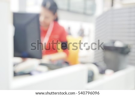 Blur abstract background air hostess ground staff working at check-in counter terminal.Blurry view receptionist work in front of computer for ticketing and loading baggage in international airport